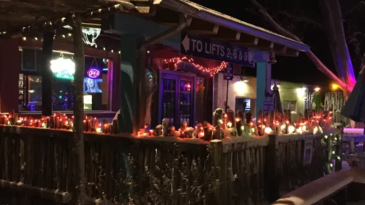 The Out Back Bar patio at night, lit with string lights