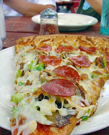 Loaded slice of pizza on the sesame-seed crust at Taos Pizza Out Back