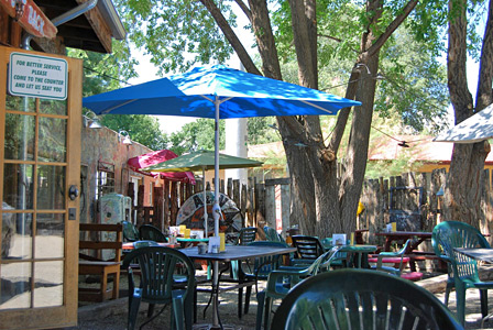 Shaded patio tables and umbrellas behind the restaurant in Taos